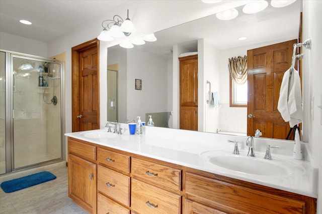 full bathroom with double vanity, a stall shower, a sink, and recessed lighting