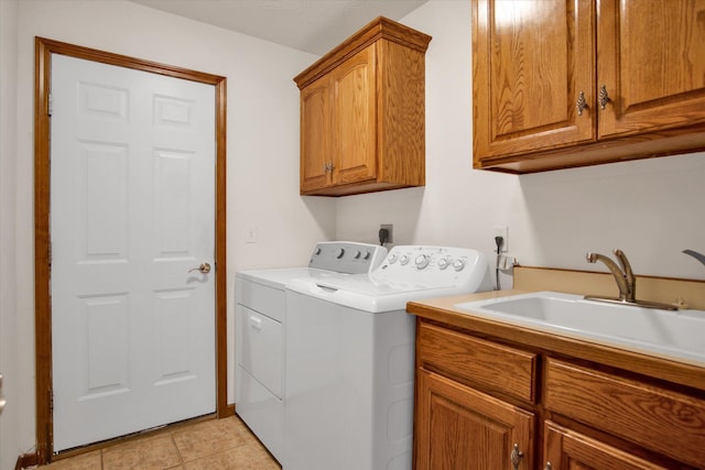 laundry room featuring light tile patterned floors, cabinet space, a sink, and separate washer and dryer