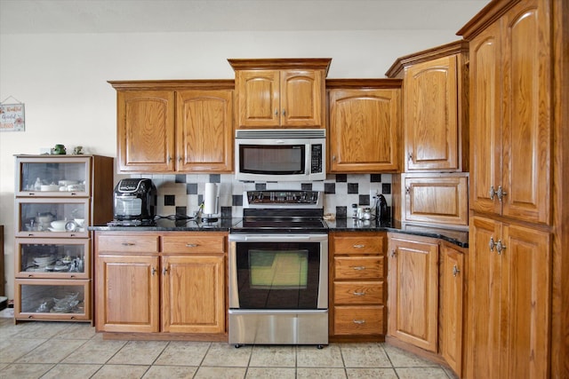 kitchen with brown cabinetry, tasteful backsplash, and stainless steel appliances