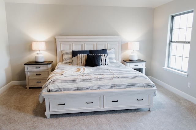 bedroom with light carpet and baseboards