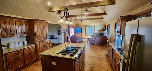 kitchen with light wood-style flooring, stainless steel appliances, beam ceiling, and open floor plan