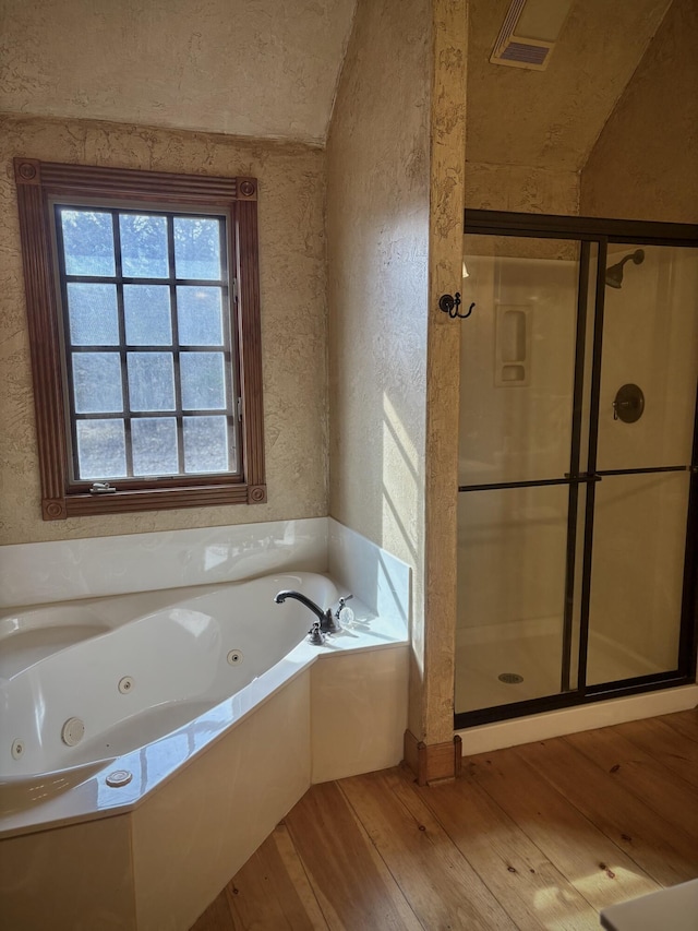 bathroom featuring a stall shower, visible vents, a whirlpool tub, and hardwood / wood-style floors