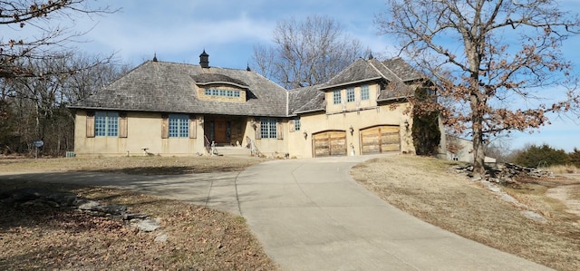 view of front of property with concrete driveway, an attached garage, and stucco siding