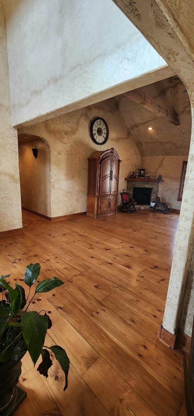 bonus room featuring light wood-type flooring and arched walkways
