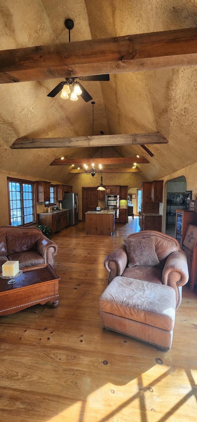 living area with ceiling fan, lofted ceiling with beams, and hardwood / wood-style floors