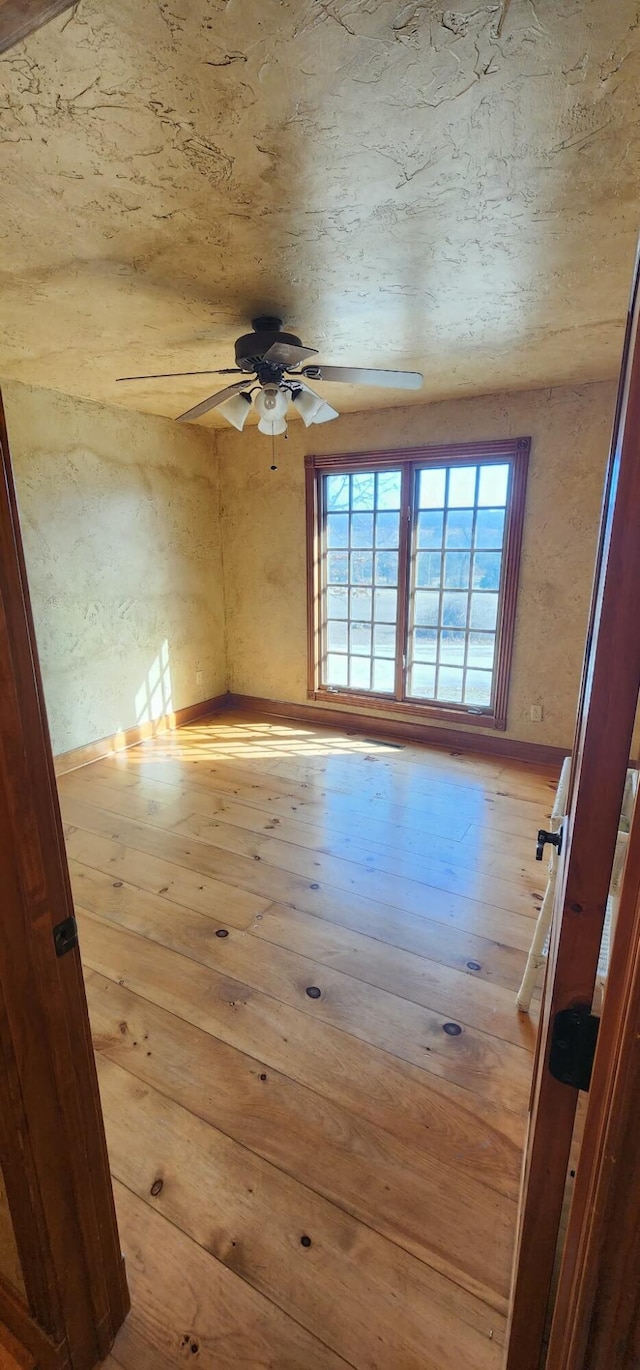 unfurnished room with ceiling fan and hardwood / wood-style flooring