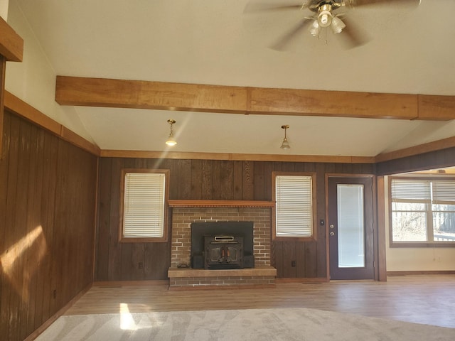 unfurnished living room with vaulted ceiling with beams, wood walls, and wood finished floors