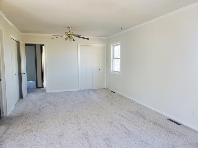 unfurnished bedroom with ornamental molding, visible vents, carpet floors, and baseboards