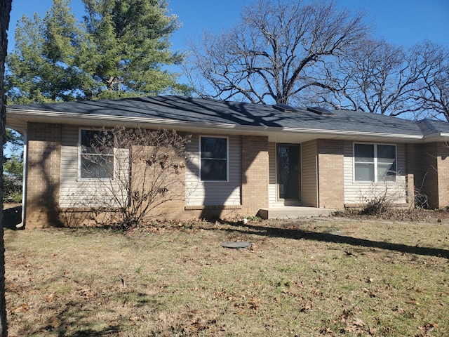 ranch-style home featuring brick siding and a front lawn