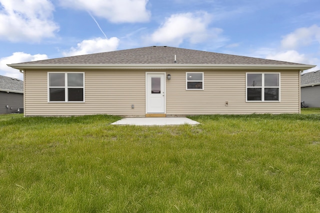 rear view of property with a patio area, a lawn, and roof with shingles