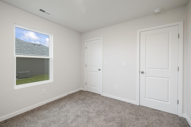 unfurnished bedroom featuring visible vents, carpet floors, and baseboards