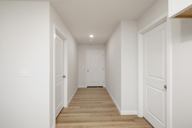 hallway featuring recessed lighting, light wood-type flooring, and baseboards