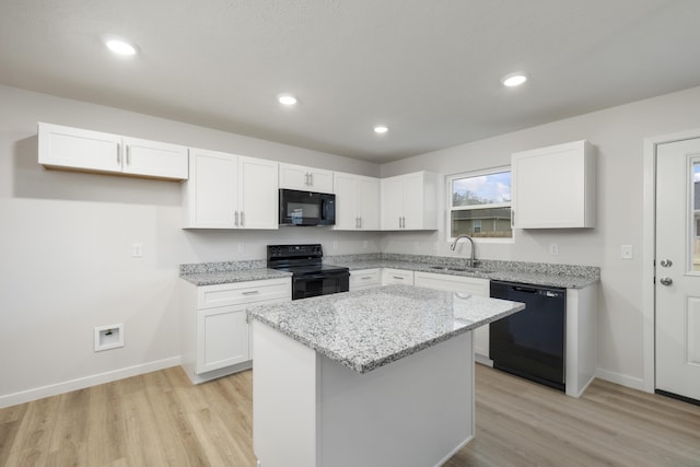 kitchen with white cabinets, black appliances, and a sink