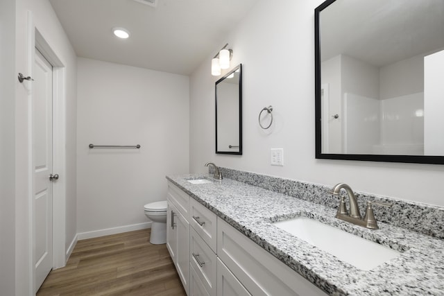 full bathroom with a sink, baseboards, toilet, and wood finished floors