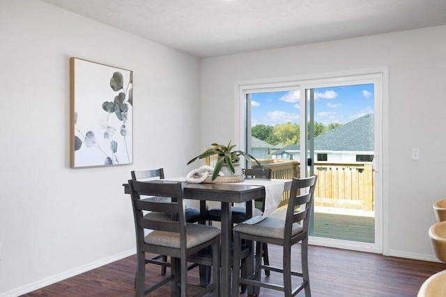 dining area with dark wood-style floors and baseboards