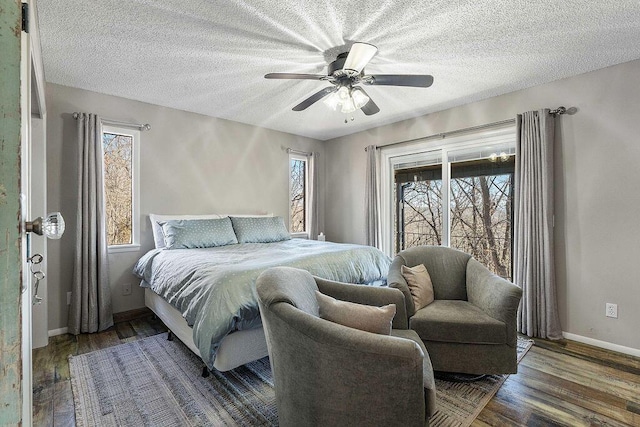 bedroom with a textured ceiling, wood finished floors, and baseboards