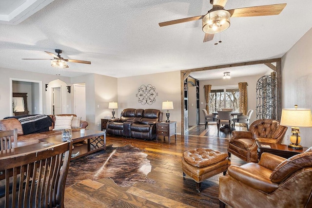 living area with a textured ceiling, hardwood / wood-style floors, and a ceiling fan