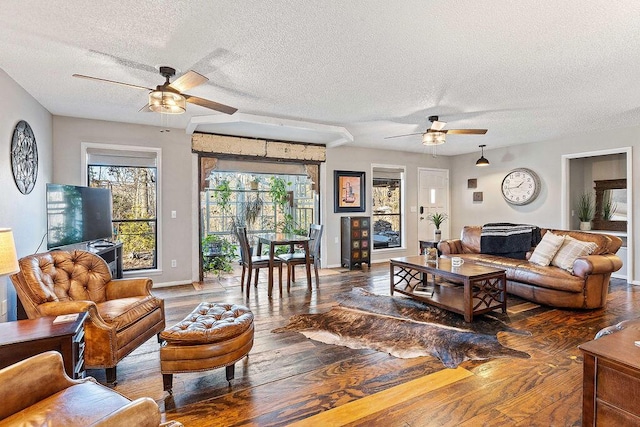 living room with baseboards, a textured ceiling, a ceiling fan, and hardwood / wood-style floors