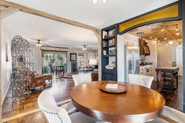 dining area with a textured ceiling, arched walkways, built in shelves, a ceiling fan, and dark wood finished floors