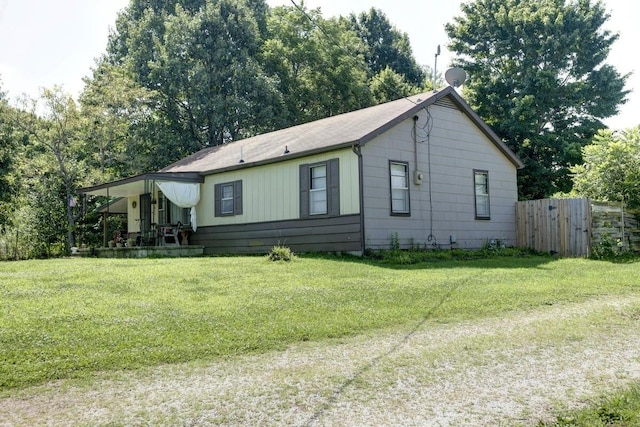 view of home's exterior with a yard and fence