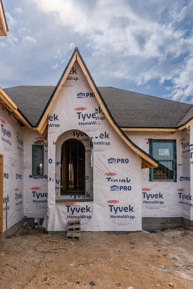 entrance to property with a shingled roof