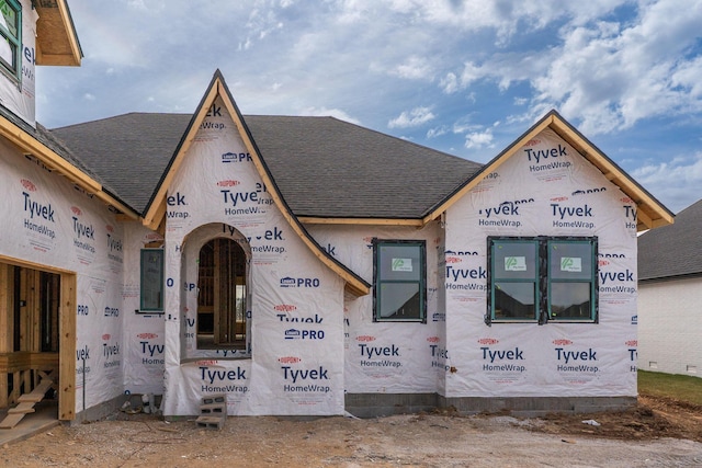 unfinished property with roof with shingles