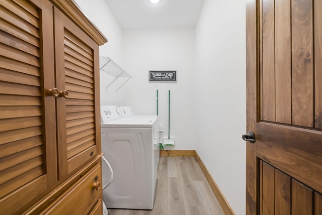 laundry room featuring washing machine and dryer, laundry area, light wood-style flooring, and baseboards