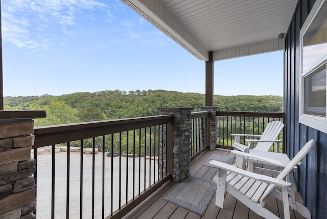 wooden deck with a wooded view