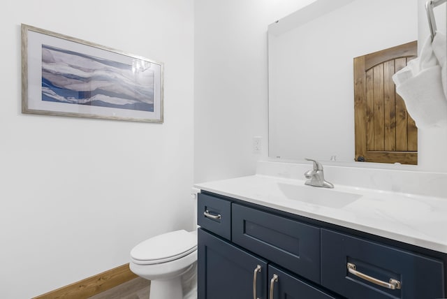 bathroom with vanity, toilet, and wood finished floors