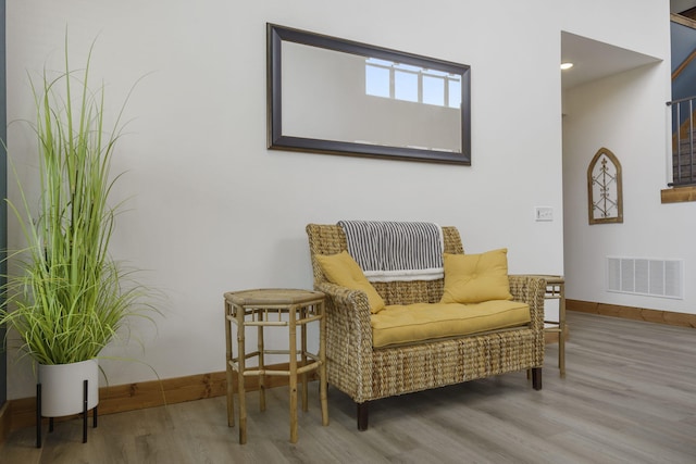 living area featuring visible vents, baseboards, and wood finished floors