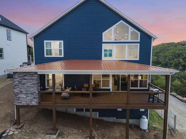 rear view of house with metal roof and cooling unit