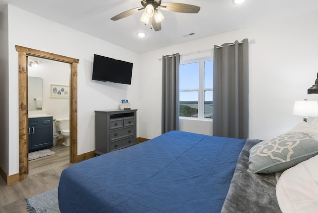 bedroom with baseboards, visible vents, a ceiling fan, connected bathroom, and wood finished floors