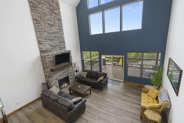 living room with a fireplace, wood finished floors, a wealth of natural light, and baseboards