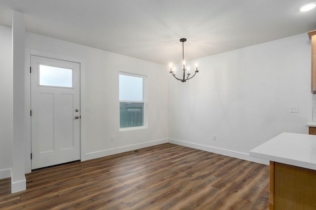 entryway featuring a healthy amount of sunlight, dark wood-style floors, and baseboards