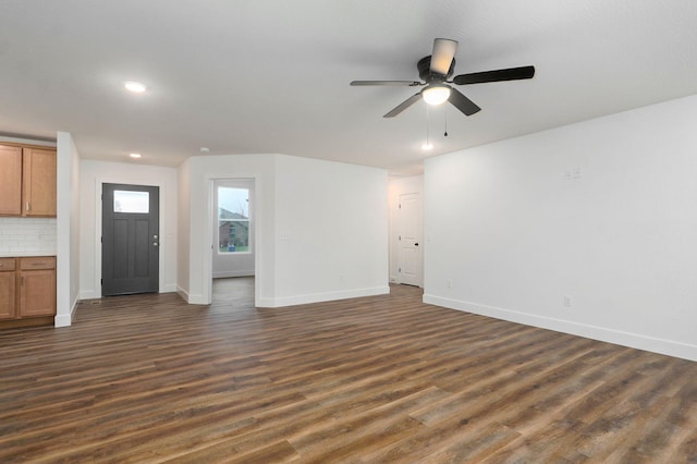 unfurnished living room featuring ceiling fan, dark wood-type flooring, recessed lighting, and baseboards