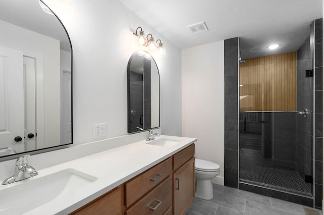 bathroom with visible vents, a sink, toilet, and tiled shower