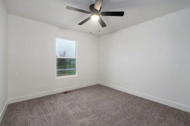 carpeted empty room featuring ceiling fan, visible vents, and baseboards