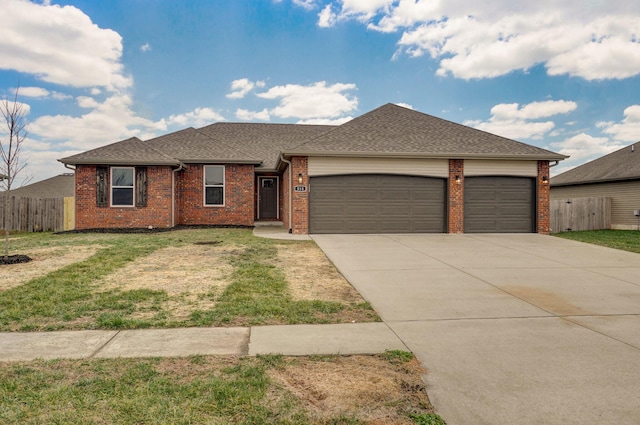 ranch-style home featuring driveway, an attached garage, fence, and a front yard