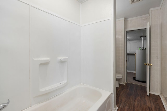 full bath featuring toilet, wood finished floors, a washtub, walk in shower, and gas water heater