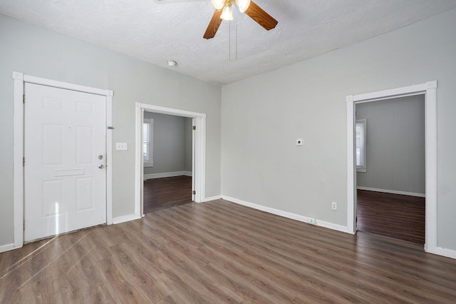 empty room featuring a ceiling fan, a textured ceiling, baseboards, and wood finished floors