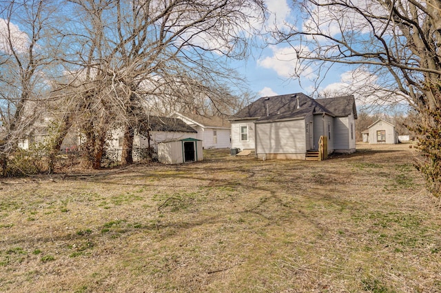 view of yard with entry steps, a storage unit, and an outbuilding