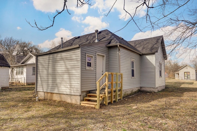 rear view of property featuring a shingled roof