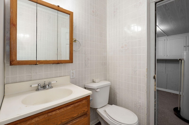 bathroom with toilet, tile walls, and vanity