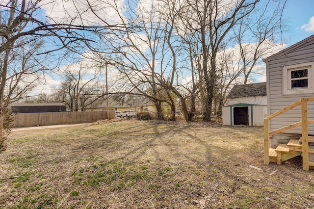 view of yard featuring fence and an outbuilding