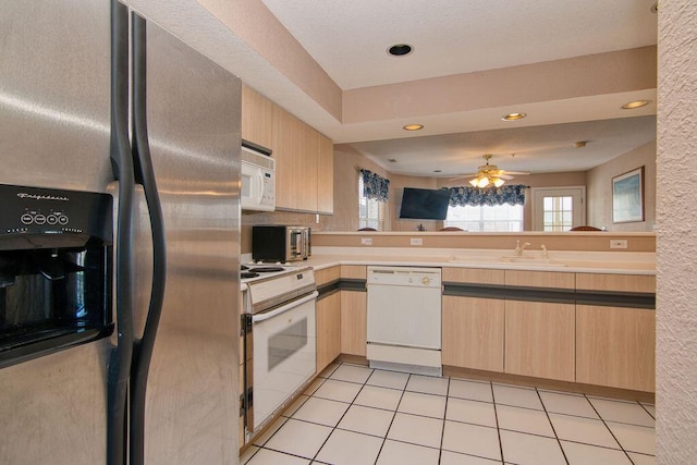 kitchen with light tile patterned floors, light brown cabinetry, white appliances, and a wealth of natural light