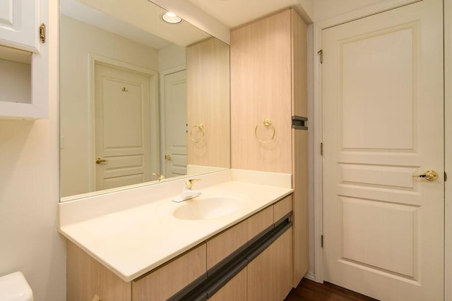 half bath featuring toilet, vanity, and recessed lighting