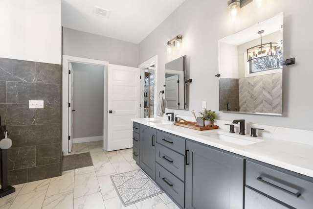 full bath with marble finish floor, visible vents, a sink, and double vanity