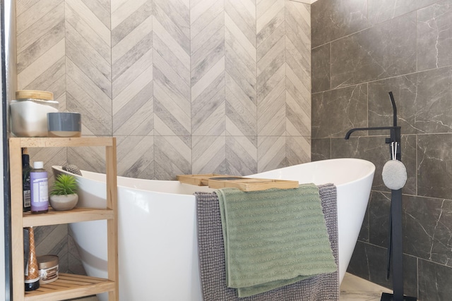 bathroom featuring a freestanding tub, tile walls, and marble finish floor