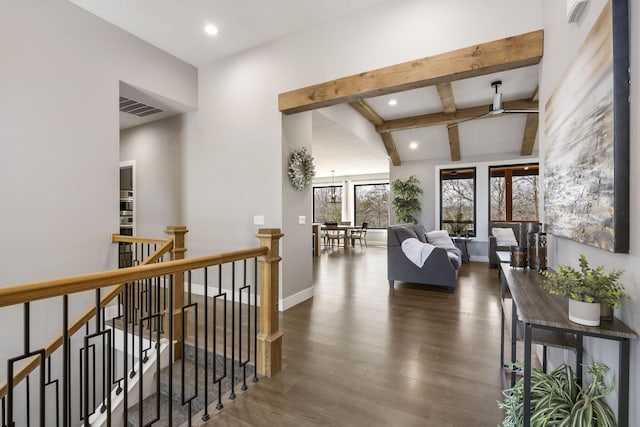 hall with baseboards, visible vents, an upstairs landing, and wood finished floors