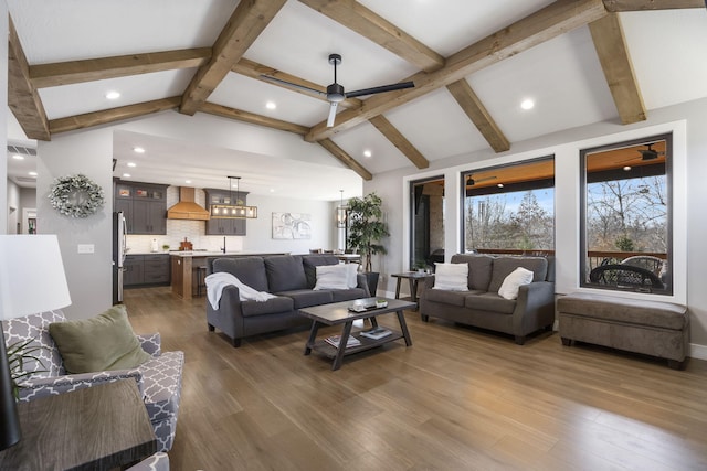 living area with visible vents, a ceiling fan, wood finished floors, vaulted ceiling with beams, and recessed lighting